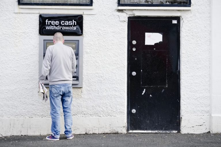 Un hombre retira efectivo de un cajero automático en Govan Glasgow